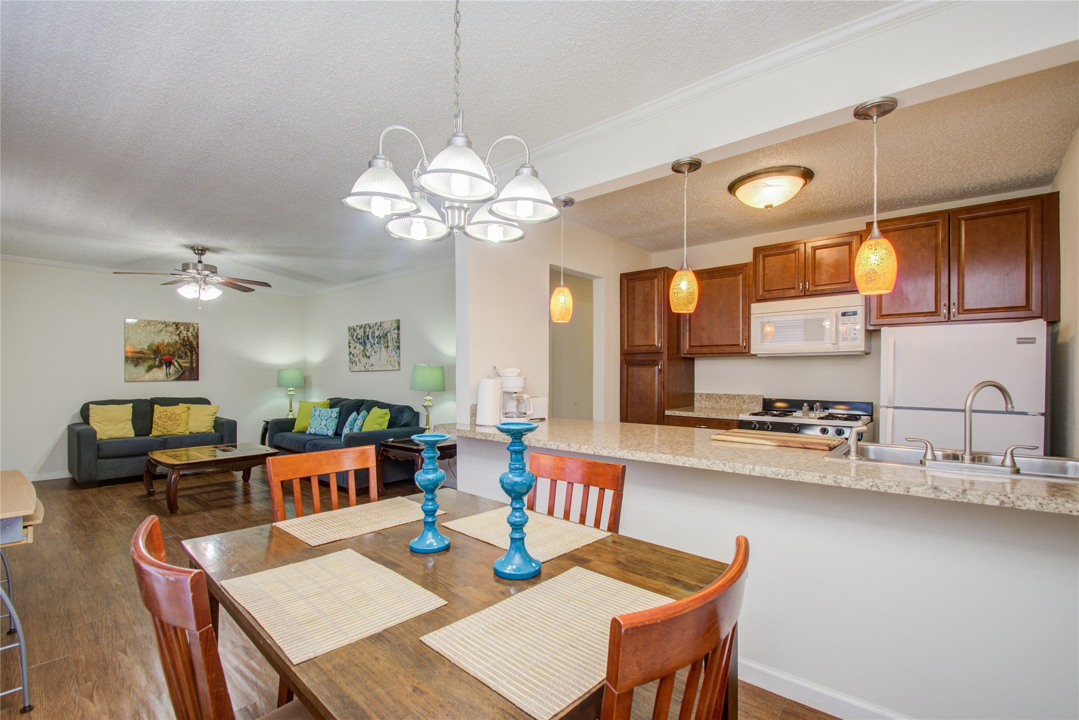 4727 West Alabama Street, Unit 2214 Houston, TX 77027 - Photo 3 of 11 a view of a dining room and livingroom with furniture wooden floor a rug a fireplace and a chandelier