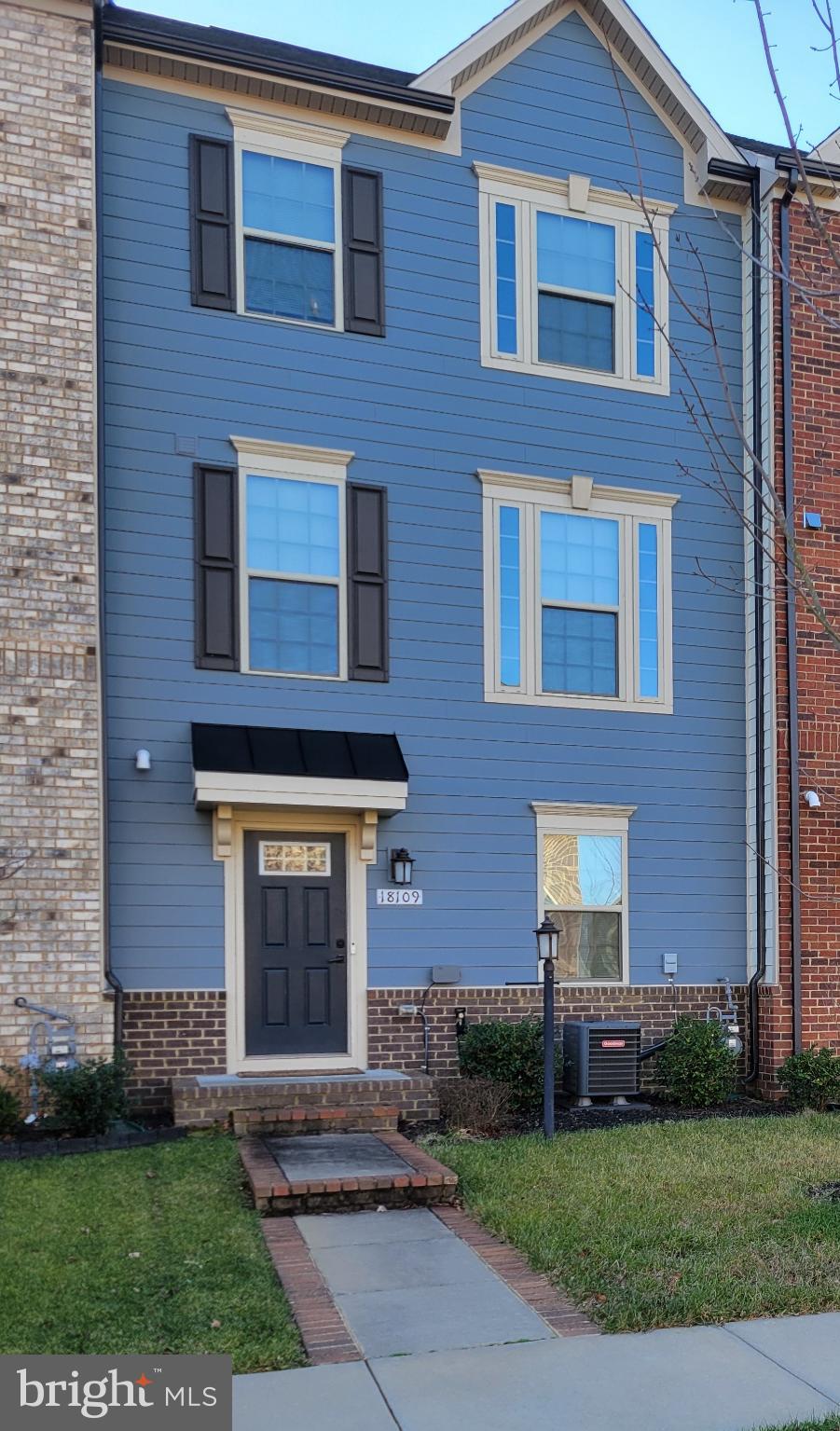 Charming blue townhouse with inviting entry.