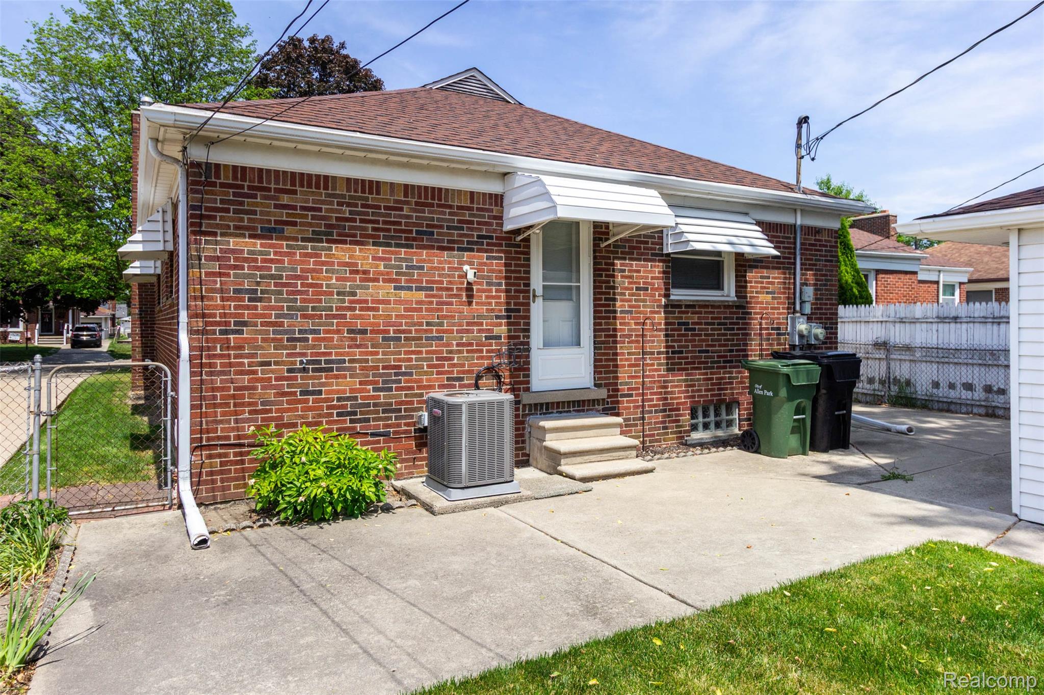 14869 Champaign Road Allen Park, MI 48101 - Photo 34 of 34 Brick exterior with a brown shingle roof, concrete patio, and white-framed awning over the rear entry