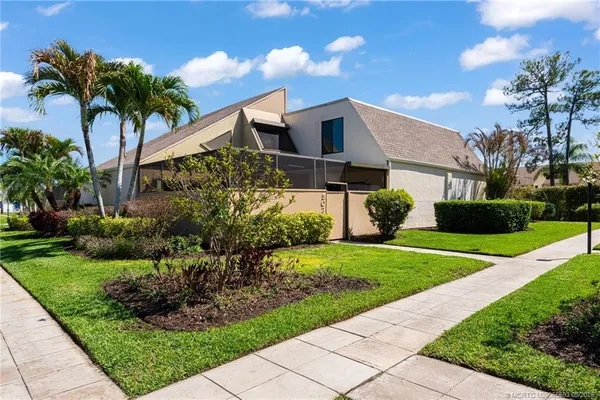 a front view of a house with a yard and potted plants