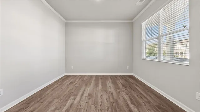 a view of a room with wooden floor and windows