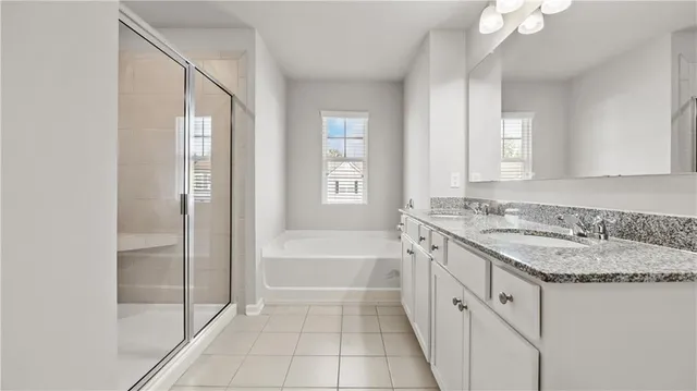 a bathroom with a granite countertop sink a mirror and a bathtub