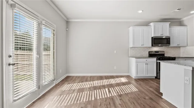 a view of kitchen with wooden floor and electronic appliances