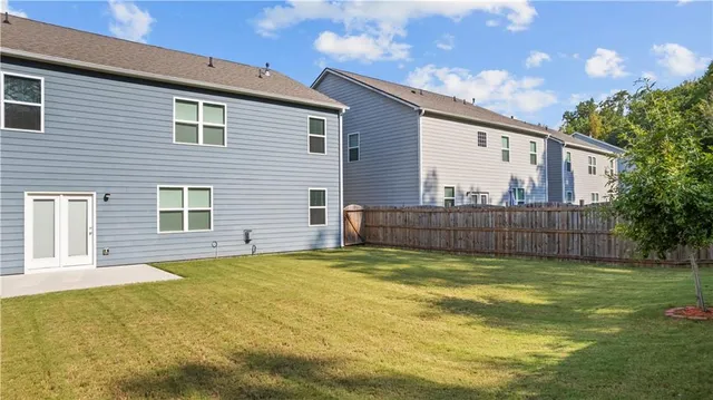 a view of a house with a yard and a large tree