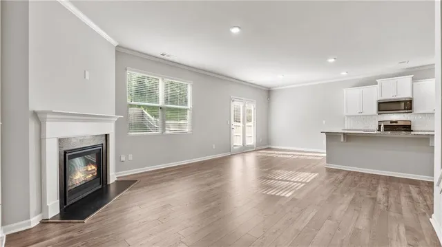 a view of empty room with kitchen and fireplace
