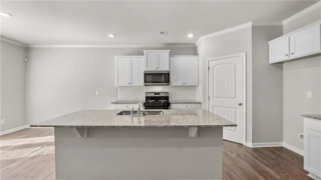 a kitchen with kitchen island a counter top space appliances and cabinets