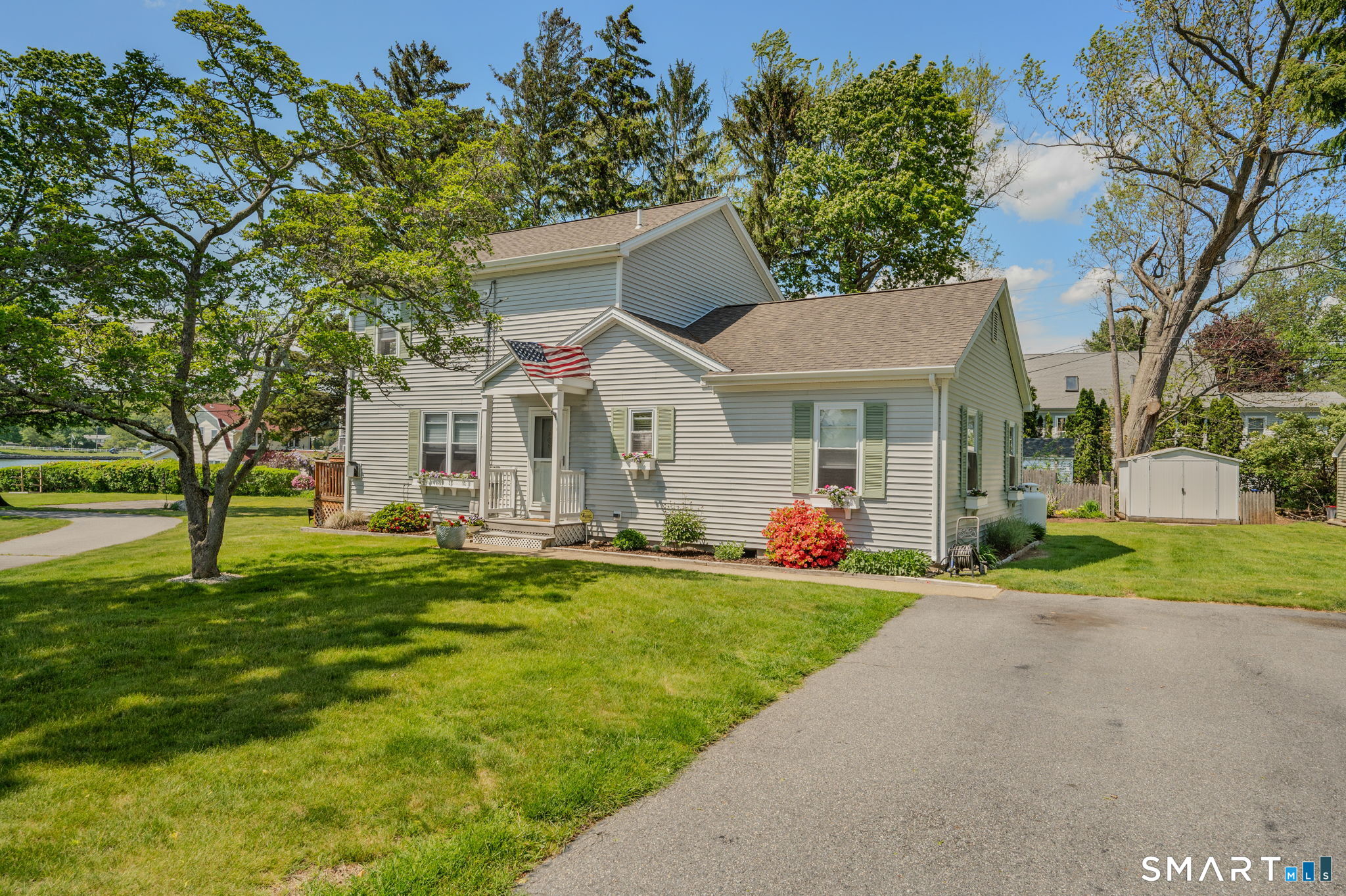 212 R Shore Road Waterford, CT 06385 - Photo 2 of 28 a front view of a house with a yard and trees