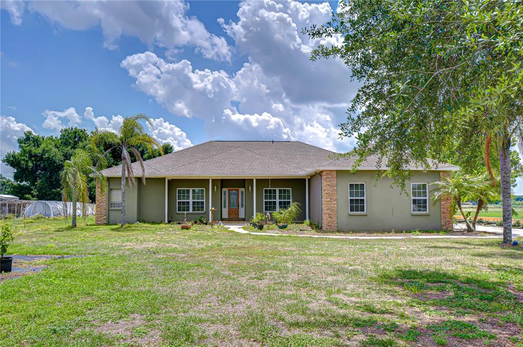 4036 Moores Lake Road Dover, FL 33527 - Photo 1 of 18 a front view of a house with a garden and trees