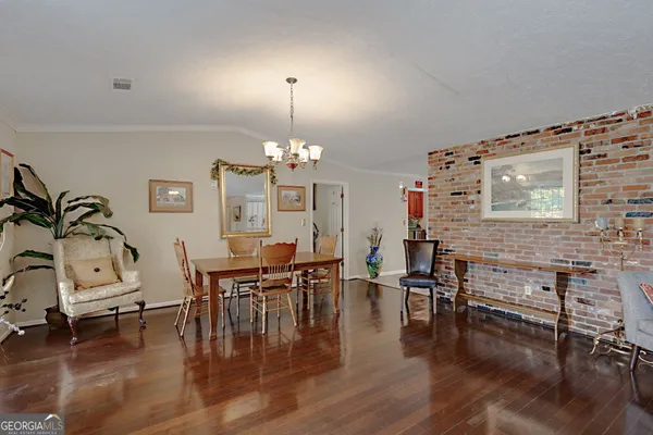 a view of a dining room with furniture chandelier and wooden floor