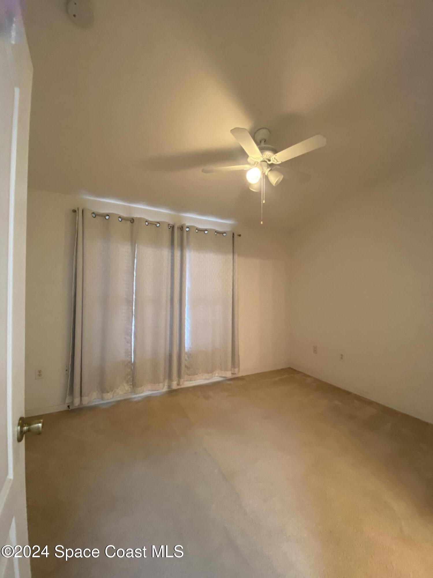 1420 Hampton Park Lane Melbourne, FL 32940 - Photo 11 of 20 an empty room with an entryway and fan