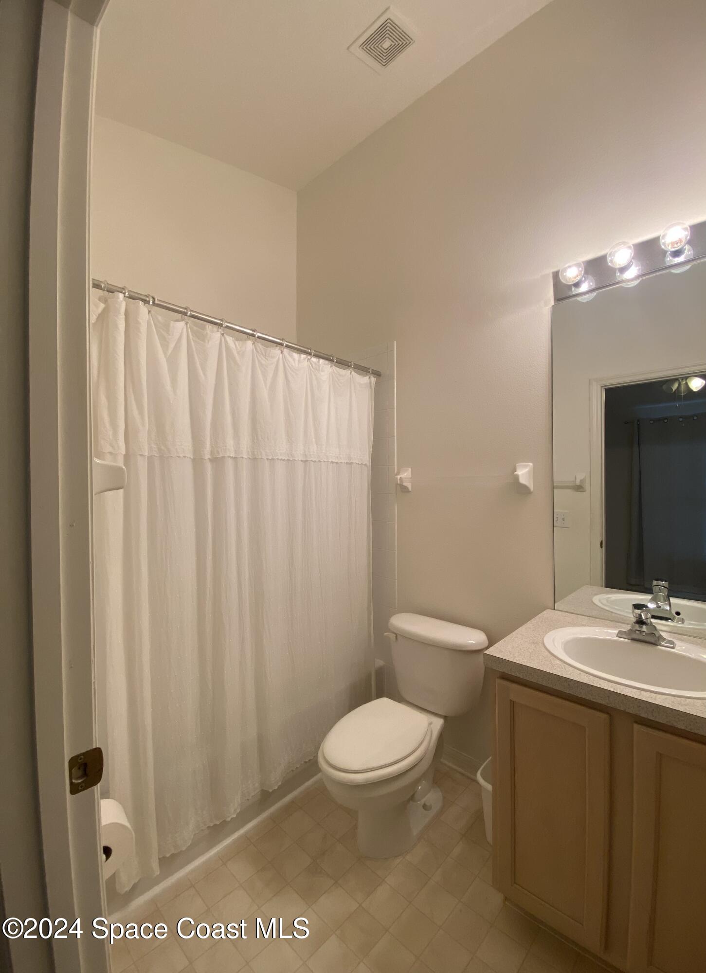 1420 Hampton Park Lane Melbourne, FL 32940 - Photo 12 of 20 a bathroom with a toilet a sink and a mirror