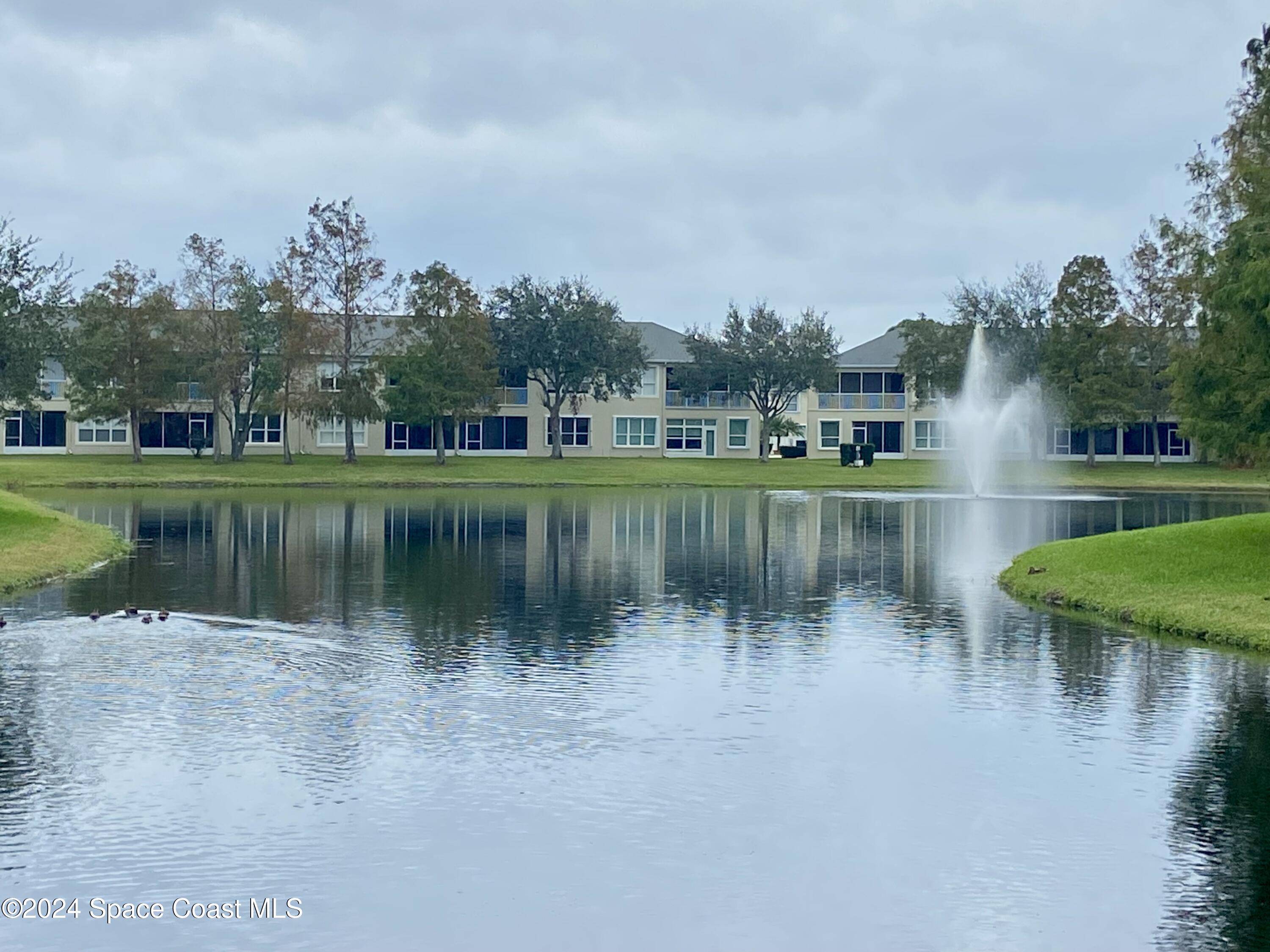 1420 Hampton Park Lane Melbourne, FL 32940 - Photo 17 of 20 a view of a lake with a building in the background