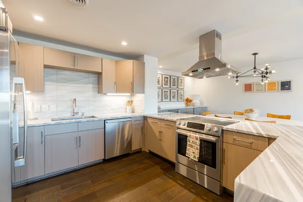 a kitchen with stainless steel appliances a sink stove and cabinets