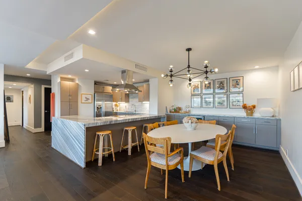 a dining area with a table chairs and a kitchen view