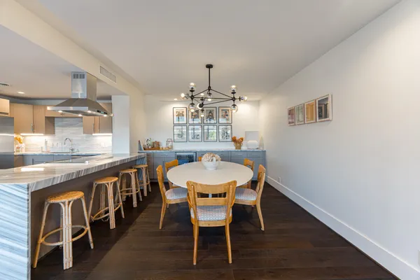 a dining room with furniture a chandelier and wooden floor
