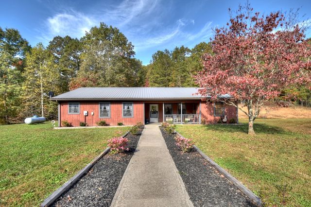 a front view of house with yard and trees