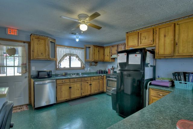 a kitchen with stainless steel appliances granite countertop a sink stove and cabinets