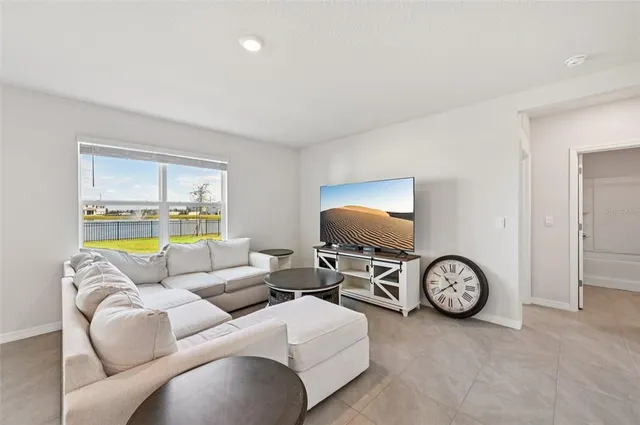 a living room with furniture a window and a flat screen tv
