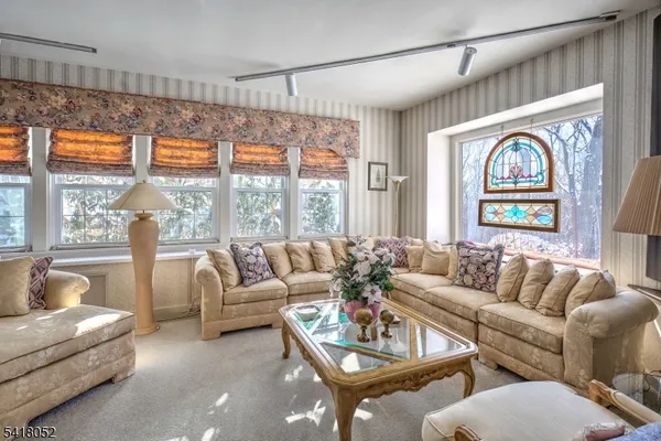 a living room with furniture fireplace and large windows