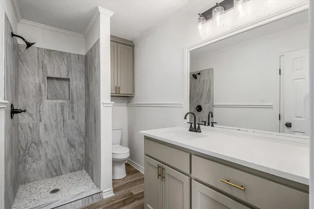 a bathroom with a sink a toilet and shower