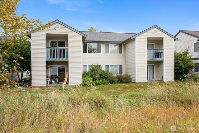 a front view of house with yard and trees in the background