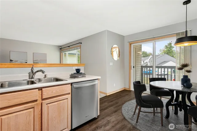 a kitchen with stainless steel appliances granite countertop a sink and dishwasher a refrigerator with wooden floor