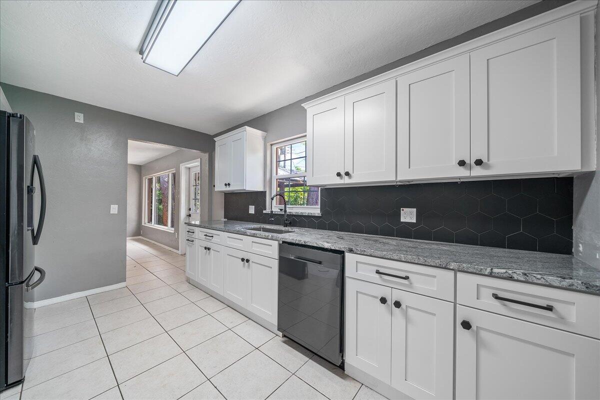 441 Sharon Drive Melbourne, FL 32935 - Photo 9 of 25 a kitchen with granite countertop white cabinets stainless steel appliances and a sink