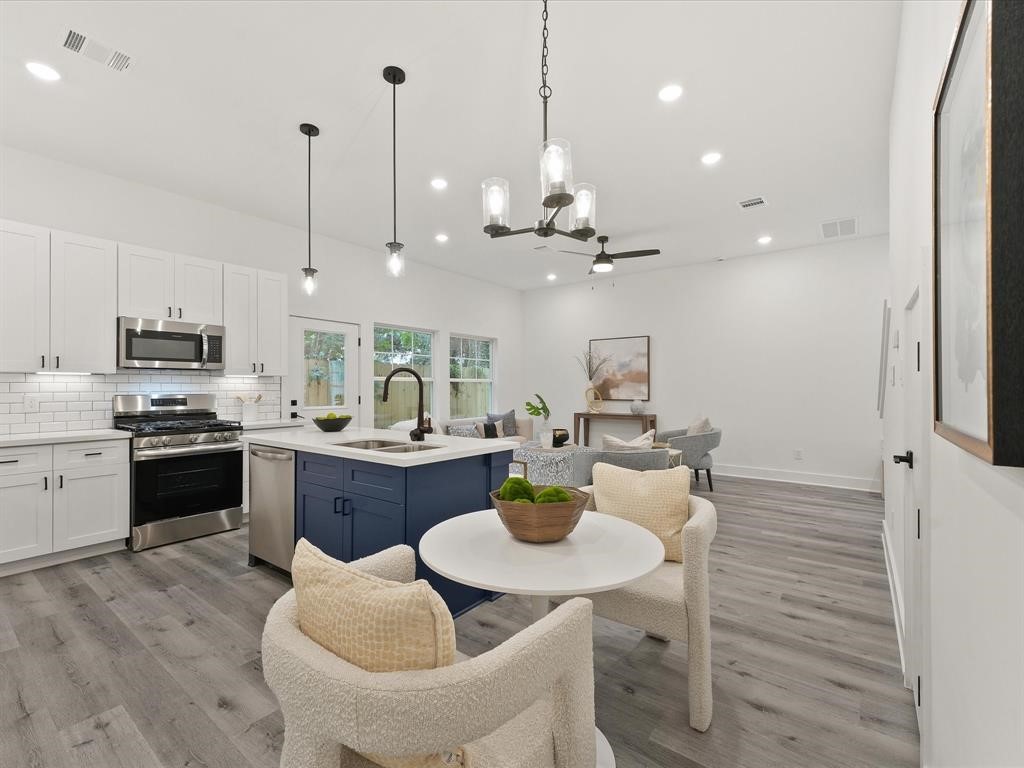 4012 Northfield Lane Houston, TX 77092 - Photo 3 of 17 a kitchen with a refrigerator a stove a dining table and chairs with wooden floor
