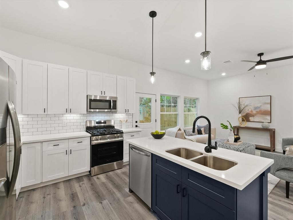 4012 Northfield Lane Houston, TX 77092 - Photo 6 of 17 a kitchen with kitchen island a sink stainless steel appliances and white cabinets