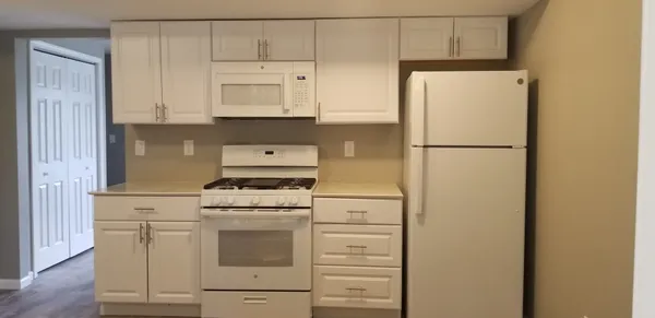 a white refrigerator freezer and a stove sitting inside of a kitchen
