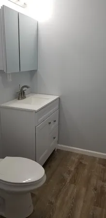 a bathroom with a toilet sink and mirror
