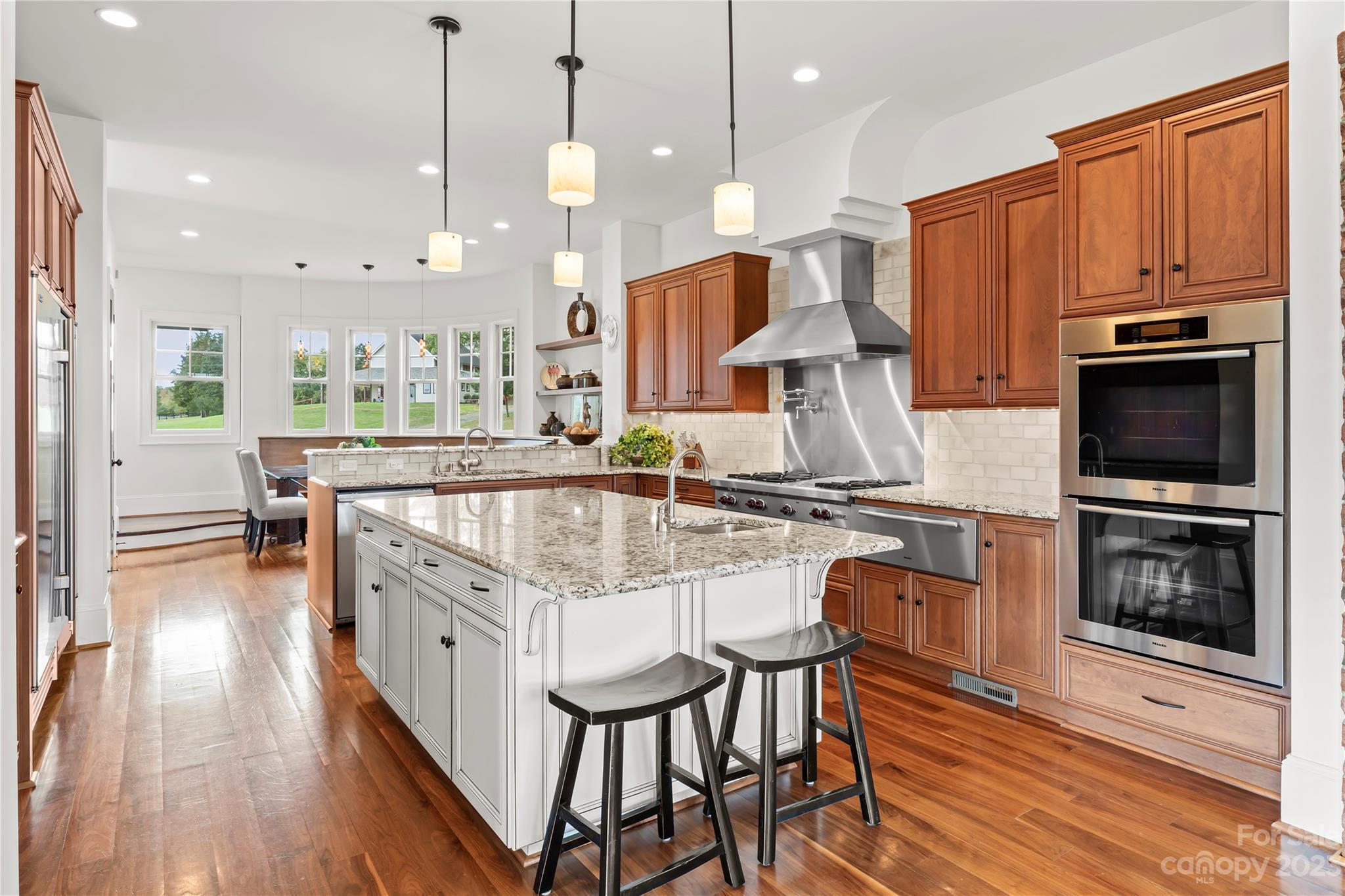 13500 Cabarrus Station Road Midland, NC 28107 - Photo 18 of 48 a kitchen with stainless steel appliances granite countertop a stove top oven a sink dishwasher a dining table and chairs with wooden floor