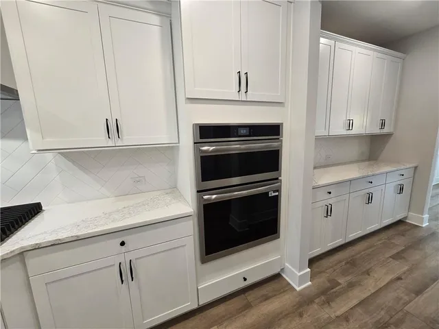 a kitchen with white cabinets and a stove