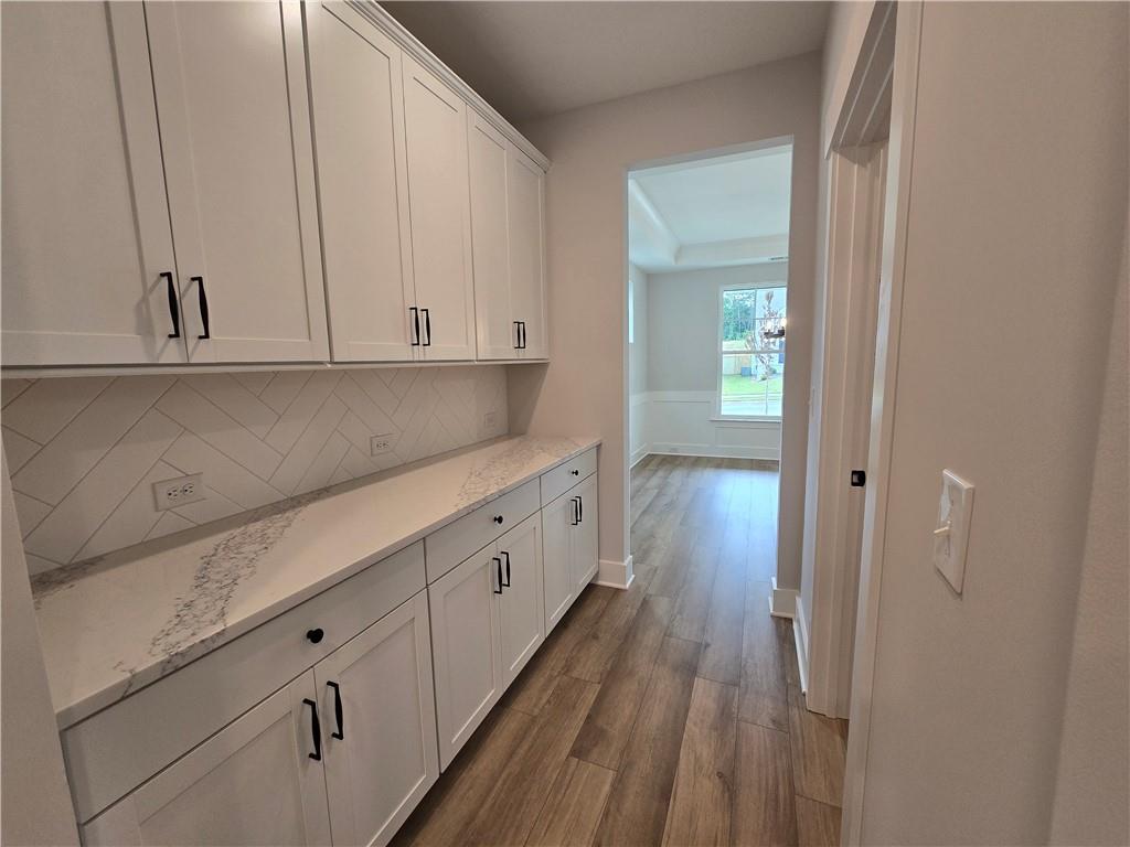 508 Pine Bough Road Ball Ground, GA 30107 - Photo 19 of 47 a kitchen with white cabinets and wooden floor