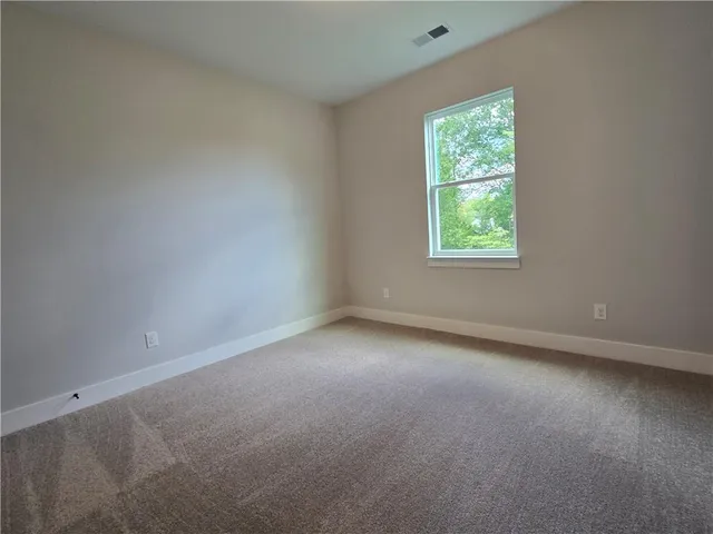 an empty room with windows and a ceiling fan