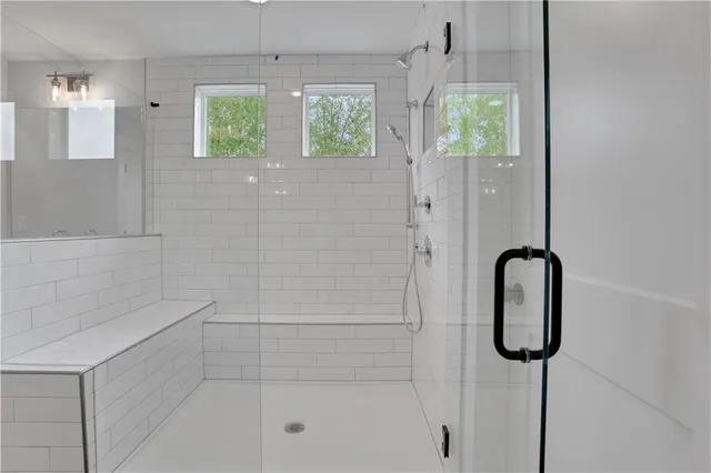 a bathroom with a sink a toilet a mirror a bathtub and shower