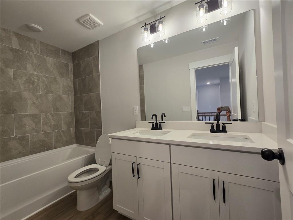 508 Pine Bough Road Ball Ground, GA 30107 - Photo 37 of 47 a bathroom with a sink a toilet a mirror a bathtub and shower