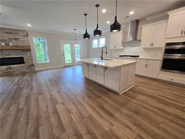 an empty room with wooden floor a fireplace and windows