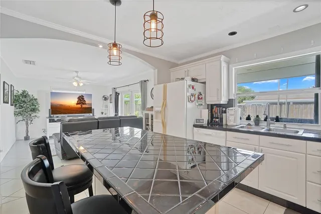 a kitchen with stainless steel appliances dining table a sink and cabinets