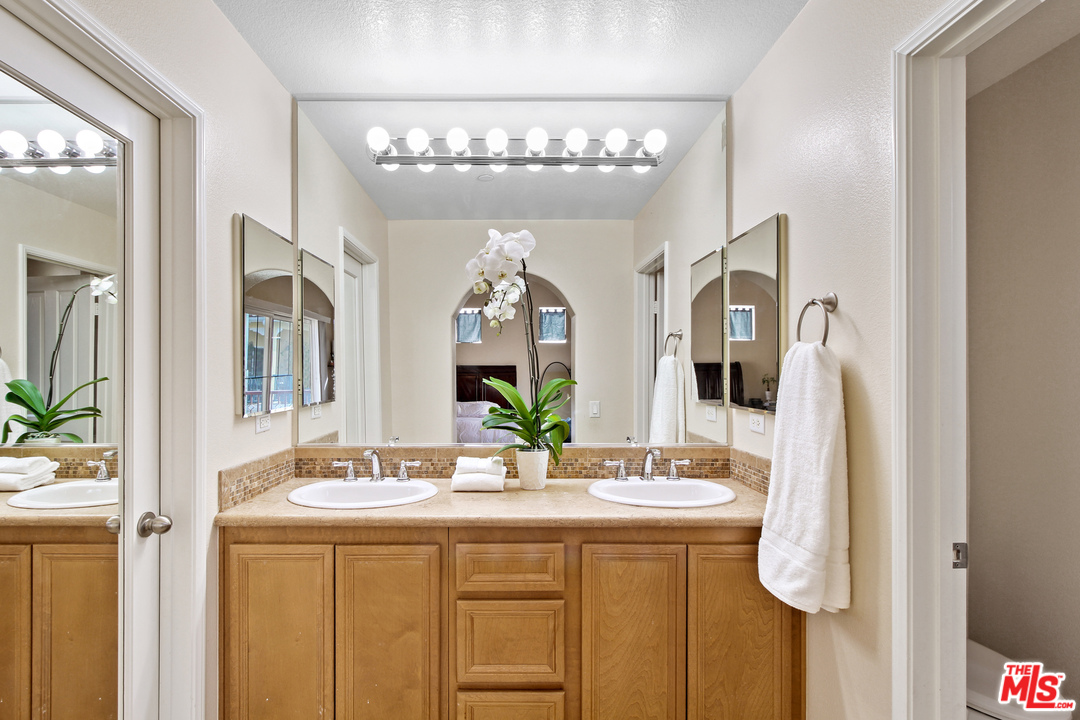 4153 Paredo Way, Unit A Simi Valley, CA 93063 - Photo 18 of 33 a bathroom with a sink a mirror and a shower