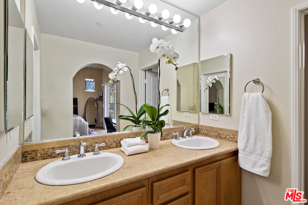 4153 Paredo Way, Unit A Simi Valley, CA 93063 - Photo 19 of 33 a bathroom with a granite countertop sink a large mirror and a sink