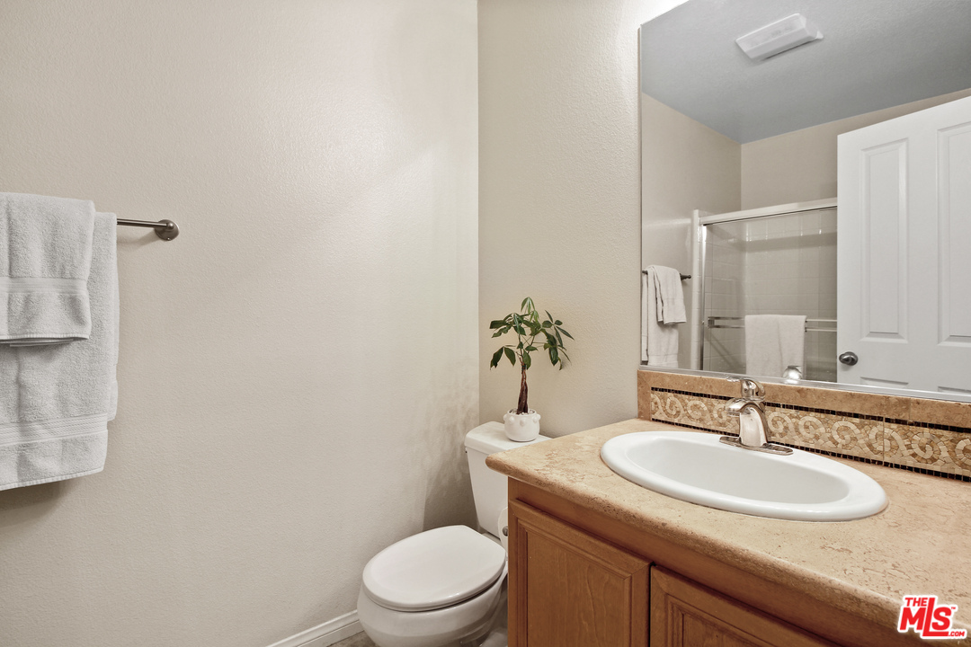 4153 Paredo Way, Unit A Simi Valley, CA 93063 - Photo 26 of 33 a bathroom with a granite countertop toilet sink and mirror
