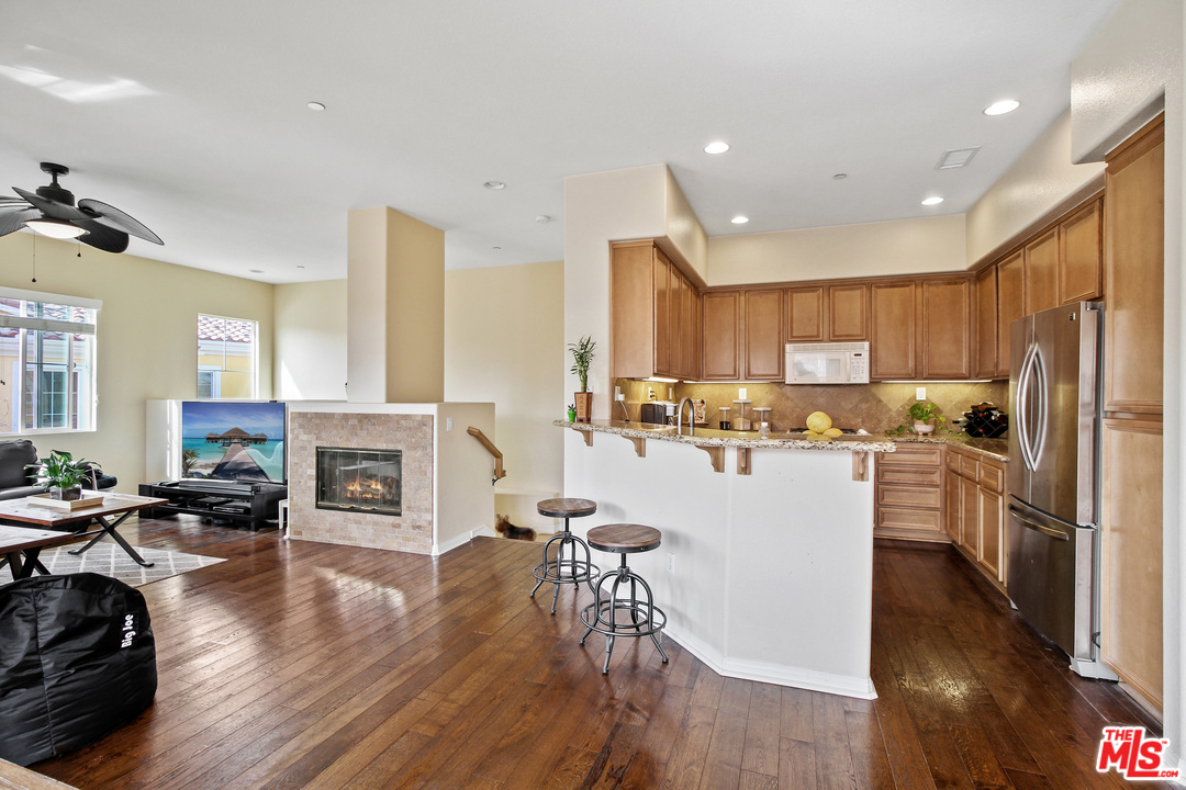 4153 Paredo Way, Unit A Simi Valley, CA 93063 - Photo 6 of 33 a living room with stainless steel appliances granite countertop furniture wooden floor and a fireplace