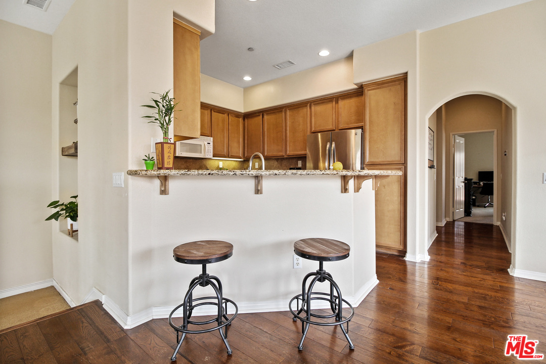 4153 Paredo Way, Unit A Simi Valley, CA 93063 - Photo 7 of 33 a kitchen with stainless steel appliances granite countertop a refrigerator and chairs