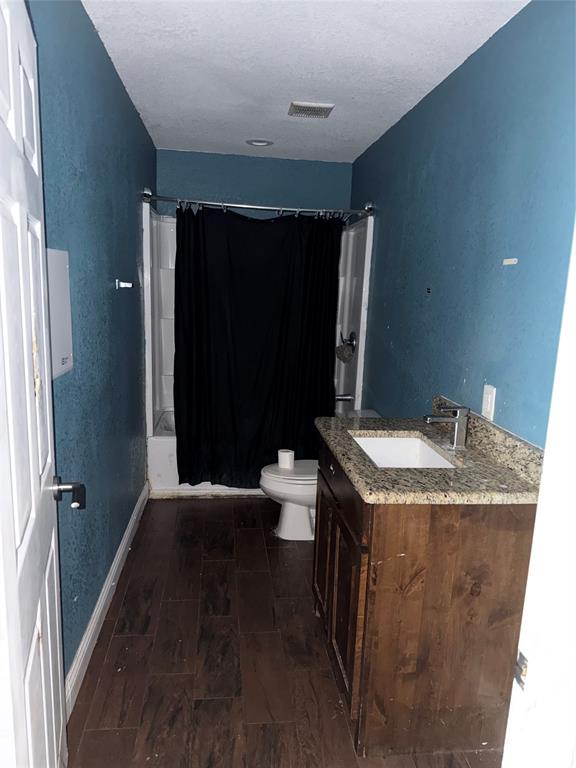 7501 Fm 3383 Road Corsicana, TX 75110 - Photo 8 of 16 Bathroom with vanity, a stall shower, a textured wall, dark wood-type flooring, and a textured ceiling