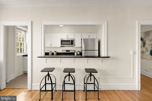 a kitchen with stainless steel appliances a stove a sink cabinets and a refrigerator