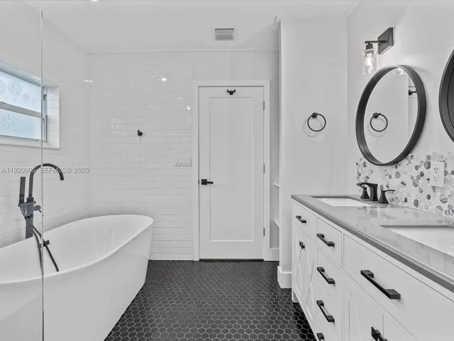 a bathroom with a tub sink and mirror