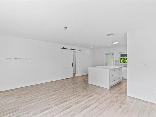a view of a kitchen with wooden floor and window