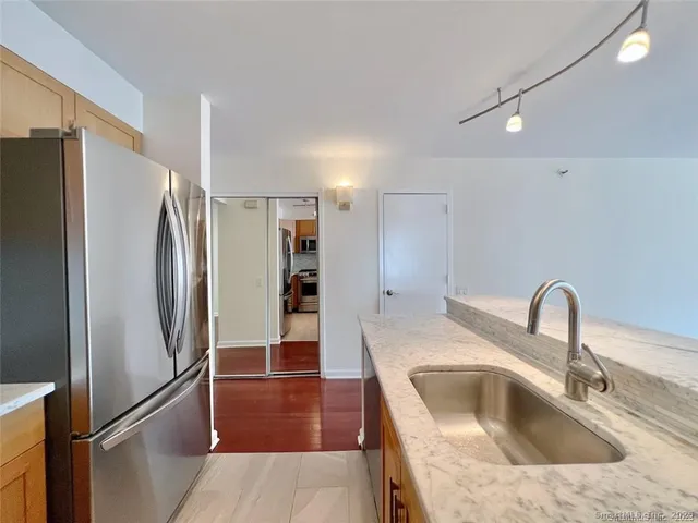 a kitchen with stainless steel appliances granite countertop a refrigerator and a sink