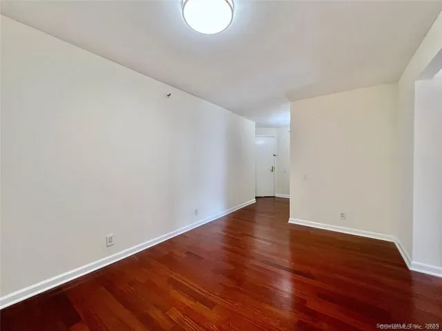 a view of an empty room with wooden floor